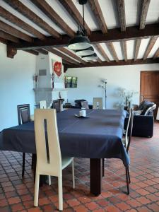 a dining room with a blue table and chairs at La villa Dakoté in Sassenay