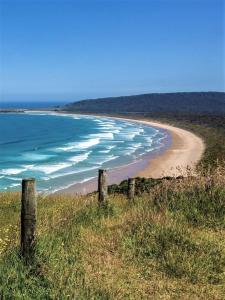 a view of a beach with a fence and the ocean at Casa em Praia Seca - Ideal para familia- Piscina- Churrasco- Em Condominio in Araruama +25 photos