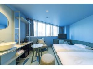 a bedroom with a large bed and a sink at toggle hotel suidobashi - Vacation STAY 18203v in Tokyo