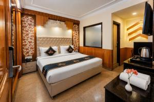 a bedroom with a large bed and a flat screen tv at Anandam Near Mall Road in Shimla