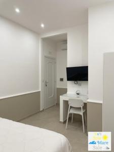 a bedroom with a bed and a desk with a television at Sole Mare Sale in Torre Nubia