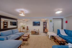 a large living room with blue couches and tables at Karen Plains Hotel Nairobi in Nairobi