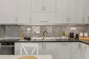 a kitchen with white cabinets and a sink at House Seda in Limenas +8 photos