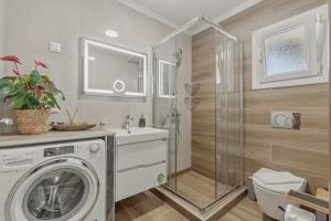 a bathroom with a washing machine and a shower at House Seda in Limenas