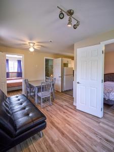 a living room with a couch and a table and a bed at Four Seasons Algonquin Cabins in Madawaska +34 photos