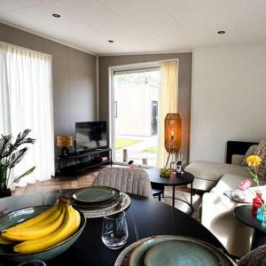 a living room with a table with bananas on it at Luxury chalet Stay Smiley with hottub - Includes FREE pool access in Heinkensand