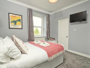 a bedroom with a bed with a flat screen tv at The Station Inn - Ribblehead in Ribblehead Station
