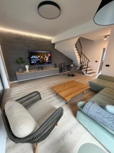 a living room with a couch and a tv at ANON Mures in Livezeni