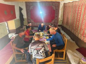 a group of men sitting at a table eating food at Auberge Restaurant Oumidou in Agoudal +35 photos