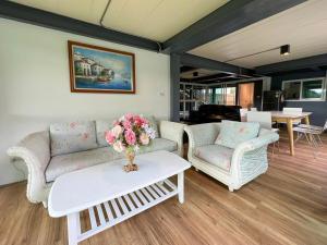 a living room with two couches and a table with flowers at Little Tree House in Mu Si