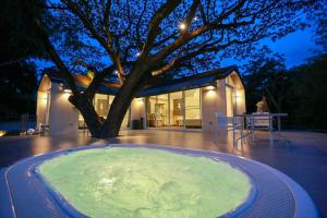 a large hot tub in front of a house at Little Tree House in Mu Si