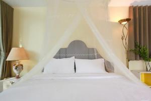 a bedroom with a white bed with a triangular headboard at Little Tree House in Mu Si +12 photos