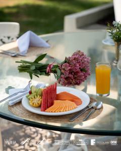 a plate of food on a glass table with a drink at Gamma Cuernavaca Puerta Paraiso in Cuernavaca