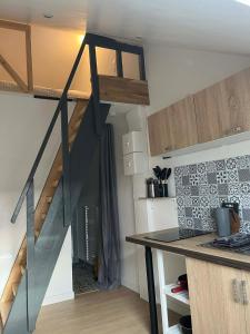 a room with a staircase and a kitchen with a counter at Studio cosy in Ham