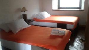 two beds in a hotel room with towels on them at La Florida Casona Hotel in Socha