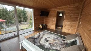 a living room with a log cabin with a large window at Domek letniskowy Jemiołowo in Olsztynek