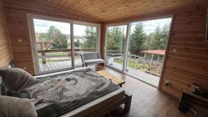 a living room with a couch in a cabin with windows at Domek letniskowy Jemiołowo in Olsztynek