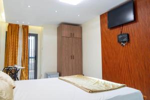 a bedroom with a bed and a tv on a wall at Résidence Madior D3 in Dakar +1 photo