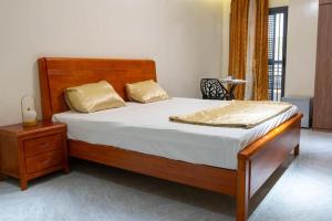 a bedroom with a large bed with a wooden headboard at Résidence Madior D3 in Dakar