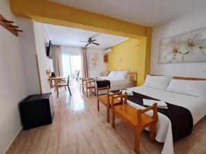 a hotel room with two beds and a table and chairs at Hotel Alaska in San Pedro del Pinatar