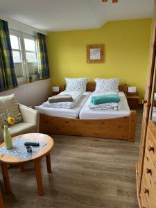 a bedroom with two beds and a couch and a table at Zum Fahrensmann in Norddorf