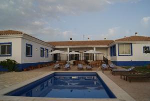 uma casa com piscina em frente a uma casa em Finca El Romeral em Alpera