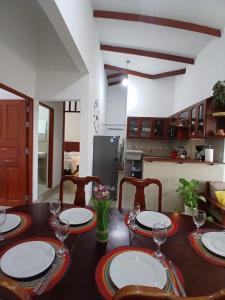a dining room table with plates and wine glasses at HEYSEN Haus in Tarapoto