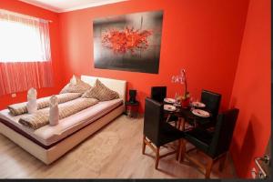 a red living room with a couch and a table at KK Vip Apartment in Palić