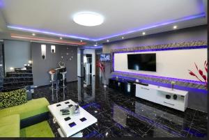a living room with a couch and a large tv at KK Vip Apartment in Palić