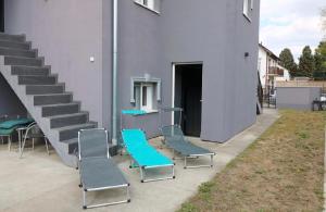 a group of chairs sitting next to a building at KK Vip Apartment in Palić