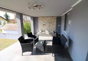 a patio with chairs and a table and a fireplace at KK Vip Apartment in Palić