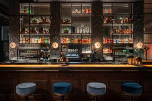 a bar with blue stools in a restaurant at Ruby Stella Hotel London by IHG in London
