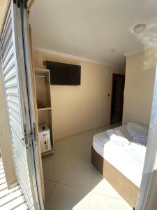 a bedroom with a bed and a flat screen tv at Basilica Palace Hotel in Aparecida