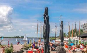 a group of people sitting at a dock with boats at Ferienhaus Chalet Spaciosa Lauwersmeer in Lauwersoog