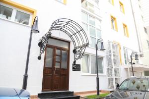 uma porta da frente de um edifício branco com uma porta castanha em Carpe Diem Apartments-Hotel em Shëngjin