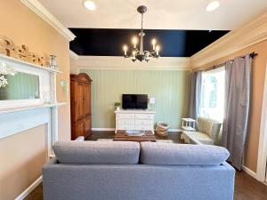 a living room with a blue couch and a tv at Haven at Hazel Downtown Loft in Demorest
