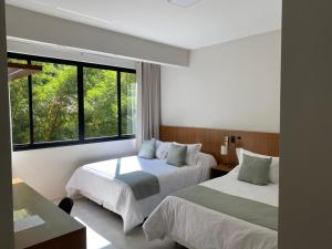 a hotel room with two beds and a window at Hotel Quinta do Lago in Cunha +53 photos
