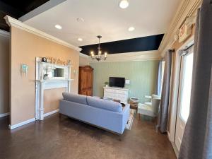 a living room with a blue couch and a television at Haven at Hazel Downtown Loft in Demorest