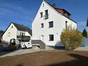 a large white house with a truck in front of it at ME Apartments - Quartier Villmar in Villmar