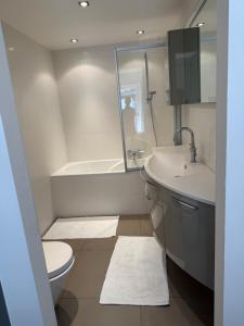 a bathroom with a toilet and a sink and a tub at Zeezicht Rubensplein - 3slpk - gratis parking in Knokke-Heist