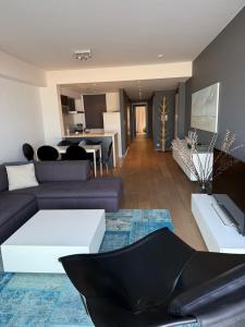 a living room with a couch and a table at Zeezicht Rubensplein - 3slpk - gratis parking in Knokke-Heist