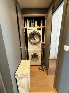 a laundry room with a washer and dryer at Zeezicht Rubensplein - 3slpk - gratis parking in Knokke-Heist