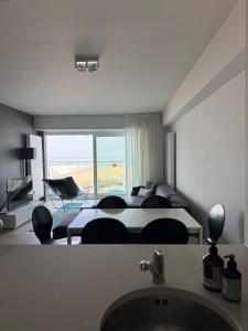 a living room with a bed and a table and chairs at Zeezicht Rubensplein - 3slpk - gratis parking in Knokke-Heist