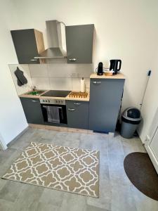 a kitchen with a stove and a rug on the floor at Apartment Leitha Living Cozy in Götzendorf an der Leitha