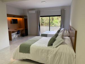 a bedroom with two beds and a large window at Hotel Quinta do Lago in Cunha