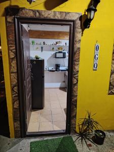 a door leading into a kitchen with a refrigerator at Casa Amarilla hostel in Bajo Boquete