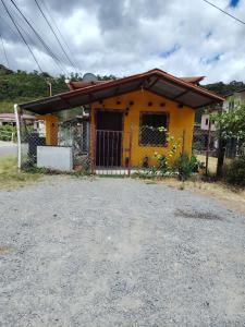 a yellow house with a gate in front of it at Casa Amarilla hostel in Bajo Boquete