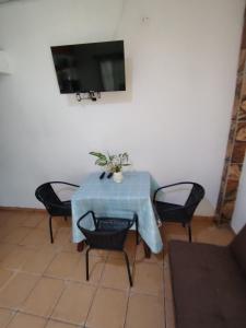 a blue table with chairs and a television on a wall at Casa Amarilla hostel in Bajo Boquete