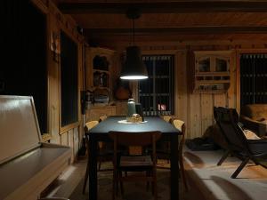 a dining room with a table and chairs and a lamp at Tronstadbu- 1800s Cabin near Geirangerfjord & Slogen Hike in Hellesylt