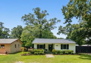 a small yellow house with a gray roof at Tiny Home in Town-Hot Tub - Privacy Fence - Fire Pit - Kids Play Area & 15 minutes to the Bogue Chitto State Park in Franklinton
